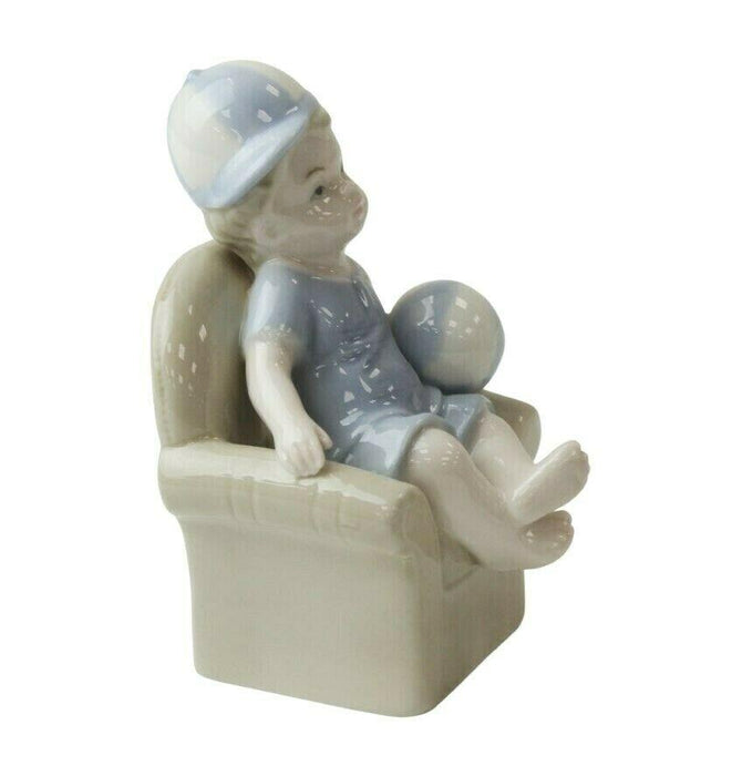 Little Boy Figurine - Young Child On Couch Small Porcelain Shelf Ornament 10.5cm